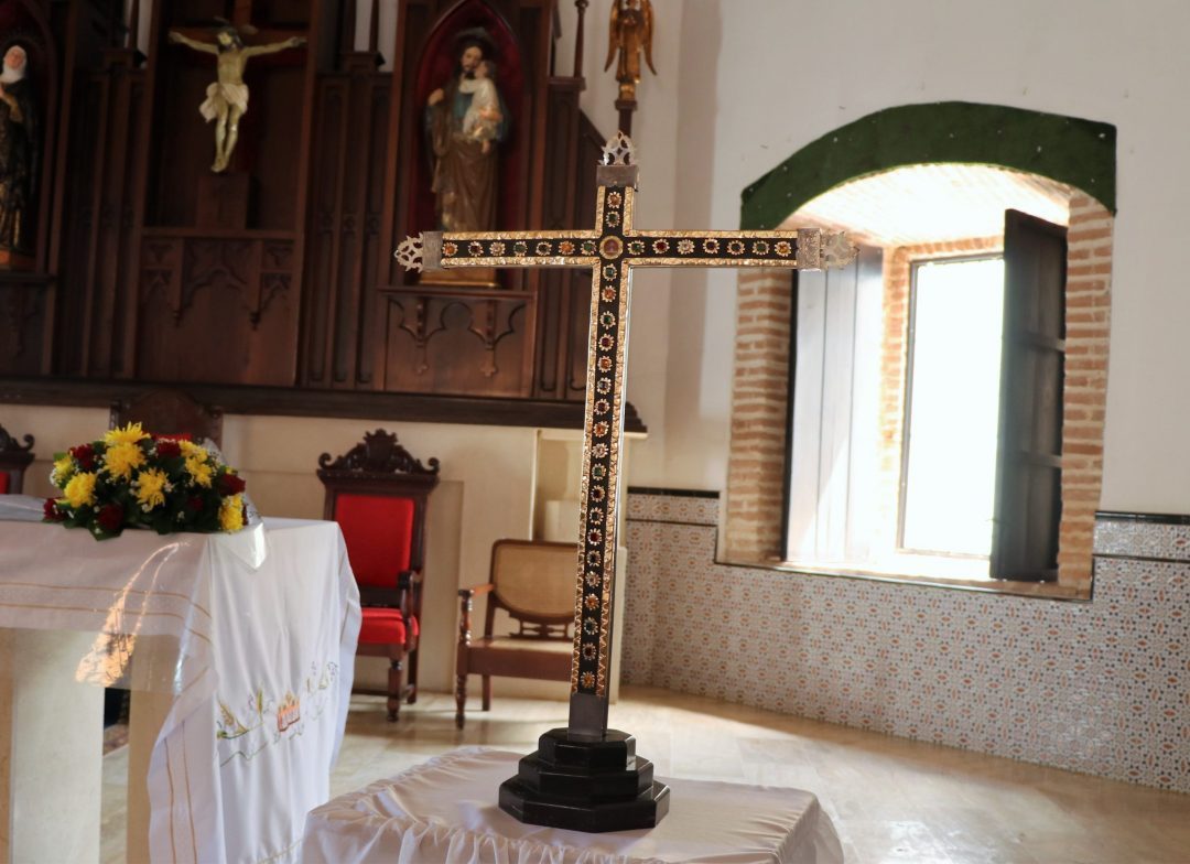 De la Cruz de ébano incrustada de plata en 1738 y de oro y joyas preciosas en 1820, ya daba cuenta en 1679 el obispo de Santo Domingo Fray Domingo Fernández. Robada y repuesta, es un símbolo de expresión de la fe.