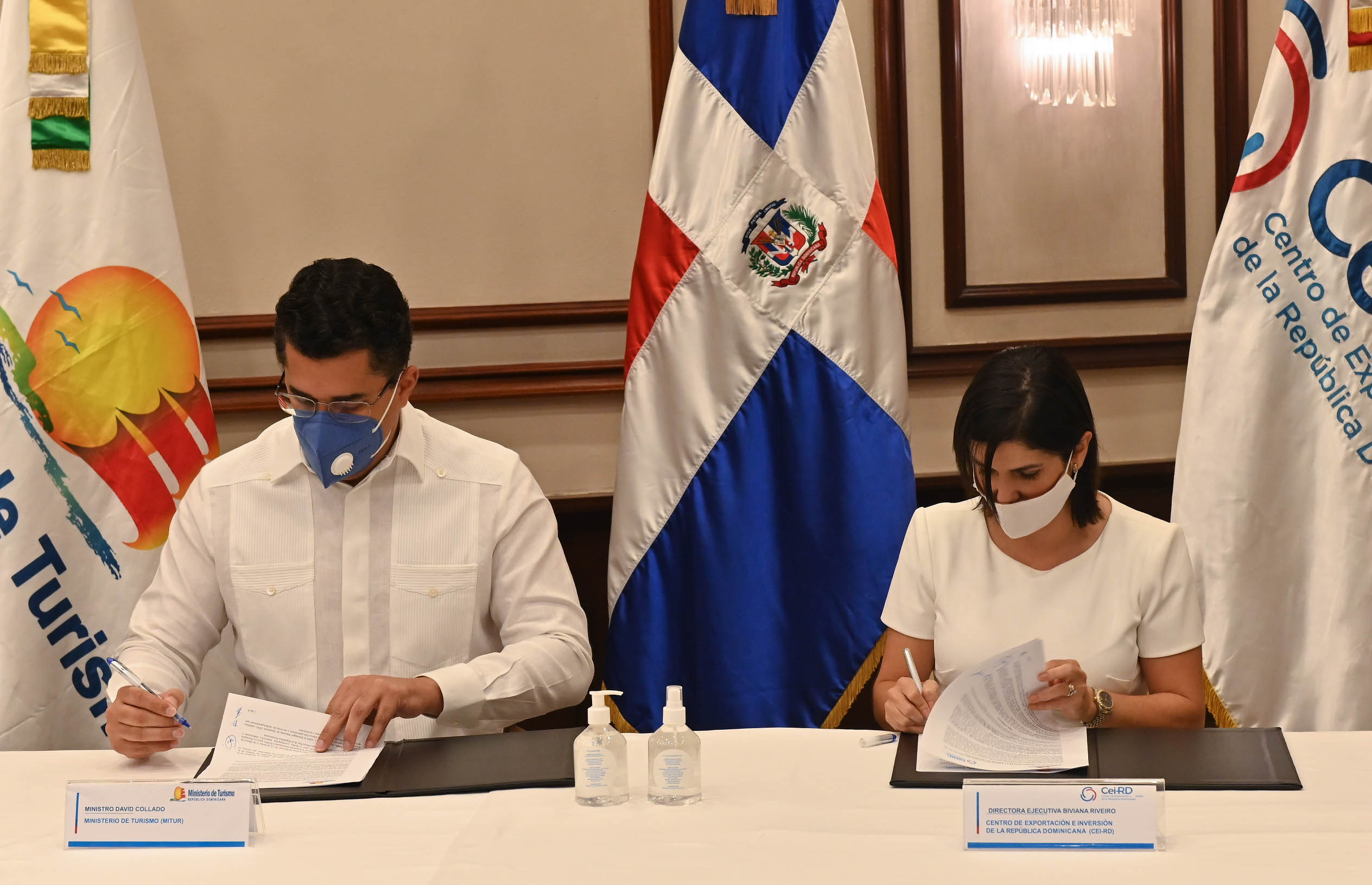 el ministro de Turismo, David Collado y la directora del Centro de Inversión y  Exportaciones (CEI-RD), Biviana Riveiro Disla durante la firma del acuerdo.