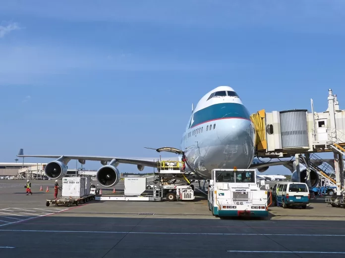 Avión siendo cargado en la pista. La IATA y la OACI amplían su cooperación en materia de normas para envíos de mercancías peligrosas