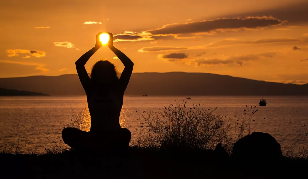 Una mujer hace yoga en una playa dominicana