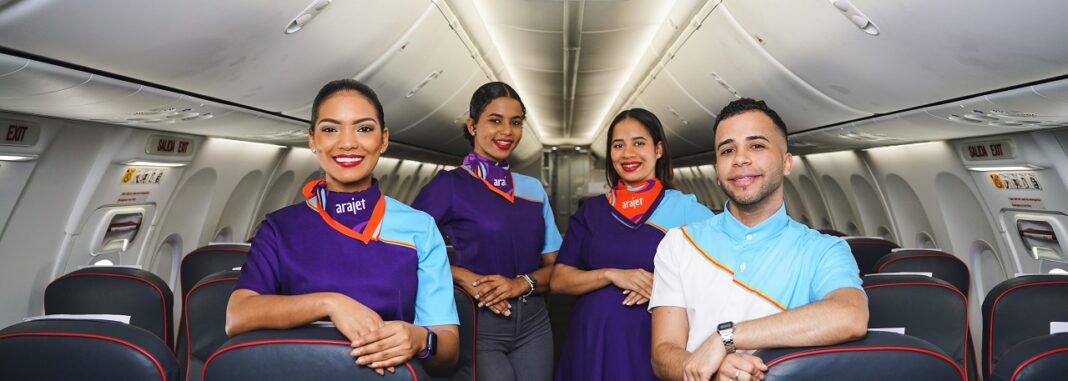 Personal de Cabina de Arajet mientras posa dentro de uno de los aviones de la línea aérea.