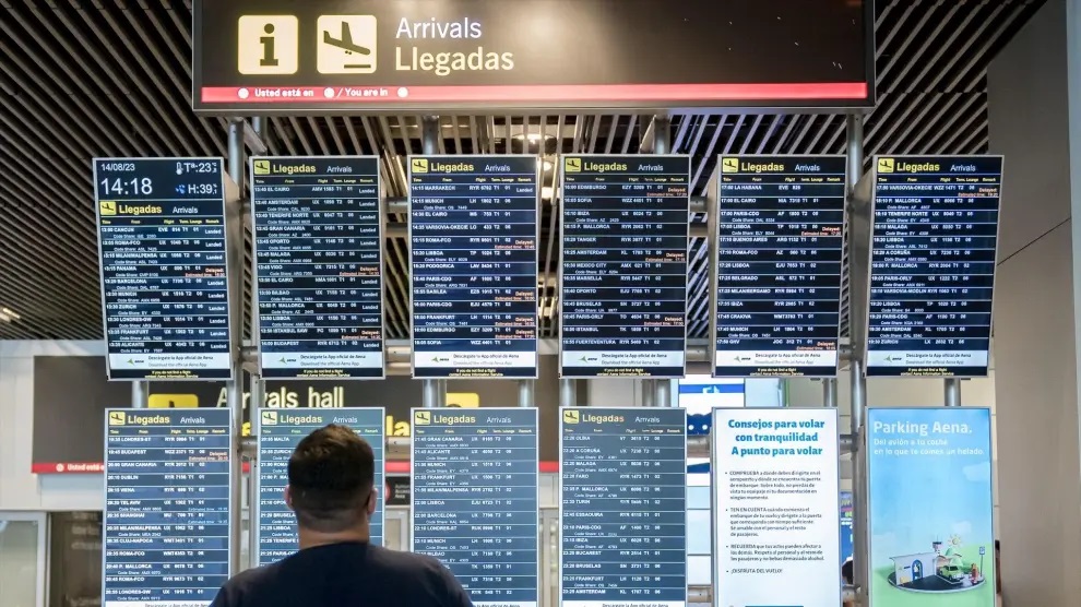 UN pasajero observa las pizarras de llegadas y salidas de vuelos en el Aeropuerto Adolfo Suárez de Madrid.