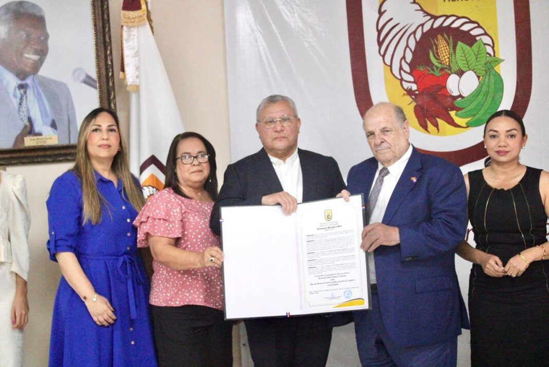 Pedro Alvarez Pastor, esposo de Bernarda Jiménez Clemente, recibe la proclama de Hija Predilecta de Moca para su fenecida esposa, de manos del alcalde Miguel Guarocuya Cabral.