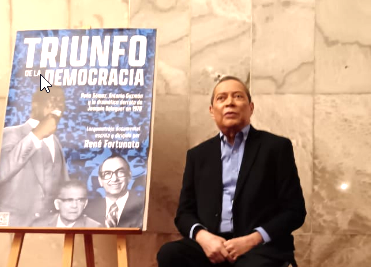 René Fortunato junto al cartel de Triunfo de la democracia.