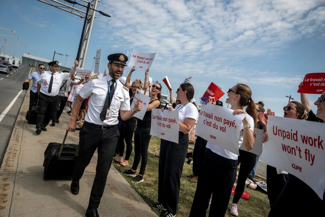 Pilotos caminan hacia las oficinas de Air Canada para comenzar a reanudar los vuelos, mientras trabajadores auxiliares los saludan sonriendo luego de deponer la huelga tras un acuerdo con la línea aérea.
