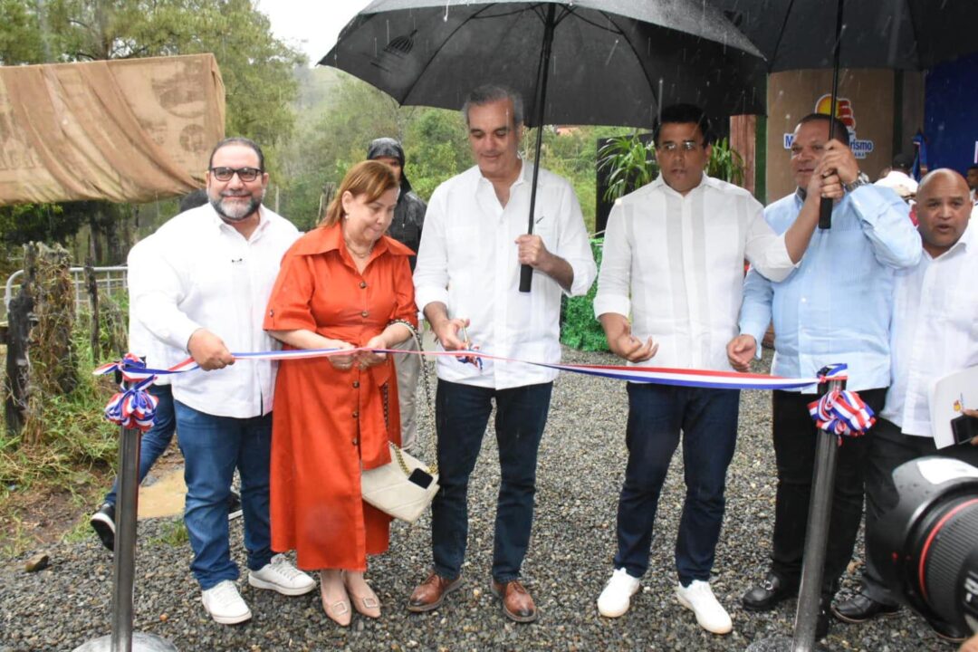 Bajo lluvia, el presidente Abinader y el ministro David Collado, cortaron la cinta para dejar inaugurada la carretera del Salto de Aguas Blancas. Les acompañan el senador Rogelio Genao, la gobernadora de La Vega y el alcalde de Constanza.