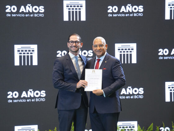 Joel Gonz&aacute;lez Pantale&oacute;n, subgerente de Programaci&oacute;n Monetaria y Estudios Econ&oacute;micos, recibe de manos del gerente, Ervin Novas Bello, el pergamino en reconocimiento a sus 20 a&ntilde;os de labores.