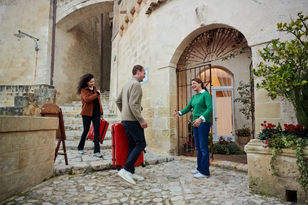 Imalgen de AIRBNB de una anfitriona recibiendo a sus huespedes en su alojamiento. Crétido AIRBNB