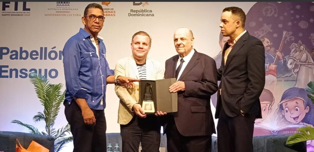 Pedro Alvarez Pastor y Pedro Luis Alvarez Jimenez, reciben de Joan Ferrer y Cristian Hernandez la placa de cristal óptico en honor de Bernarda Jimenez Clementre.