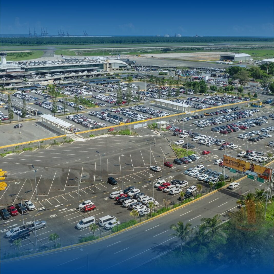 Vista aérea del Aeropuerto Internacional de Las Américas con sus parqueos en primer plano.