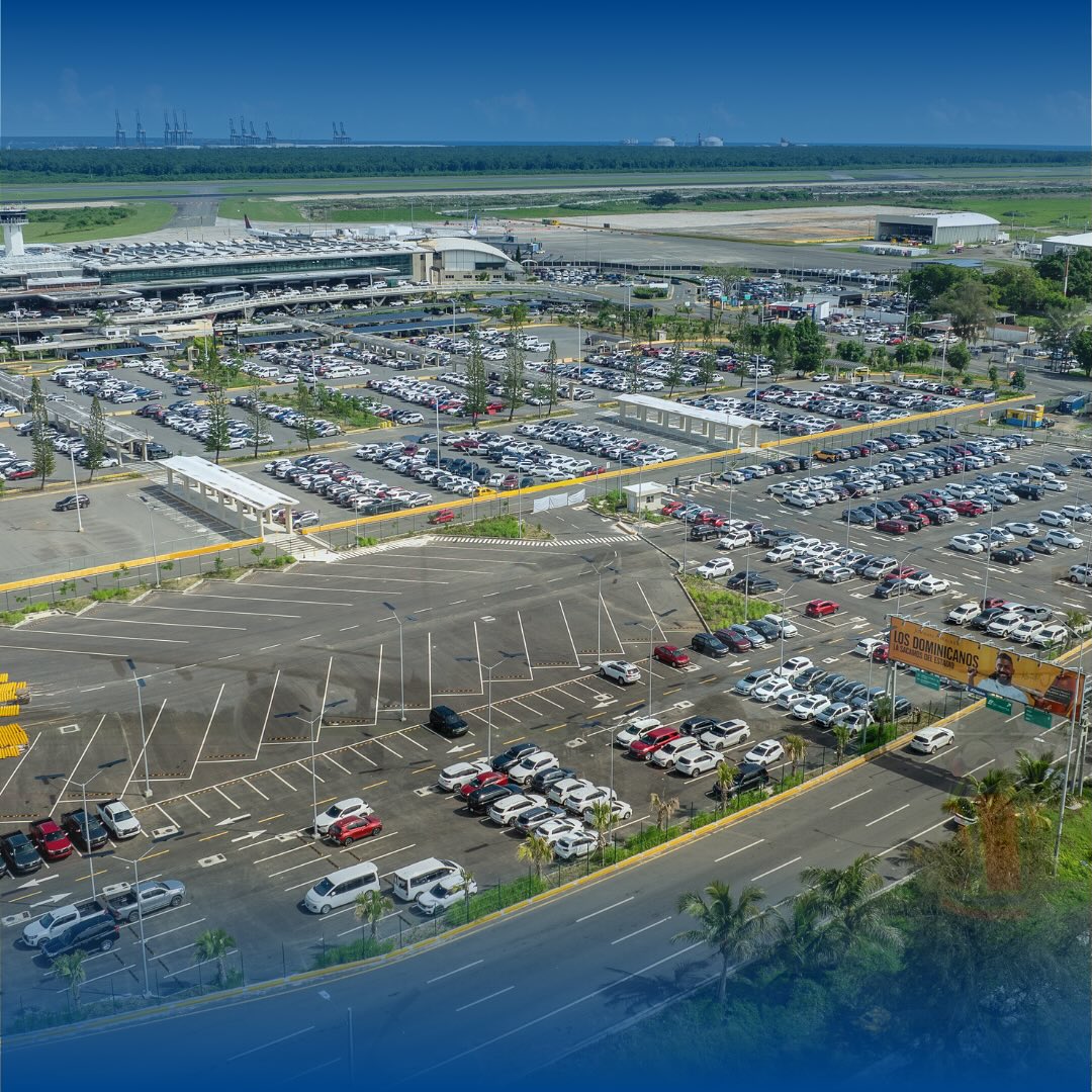 Vista aérea del Aeropuerto Internacional de Las Américas con sus parqueos en primer plano.