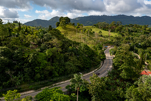 Vista de la Carretera Turística La Cumbre en República Dominicana,  una ruta panorámica icónica que conecta Santiago con Puerto Plata, ofreciendo vistas espectaculares del océano y las montañas.