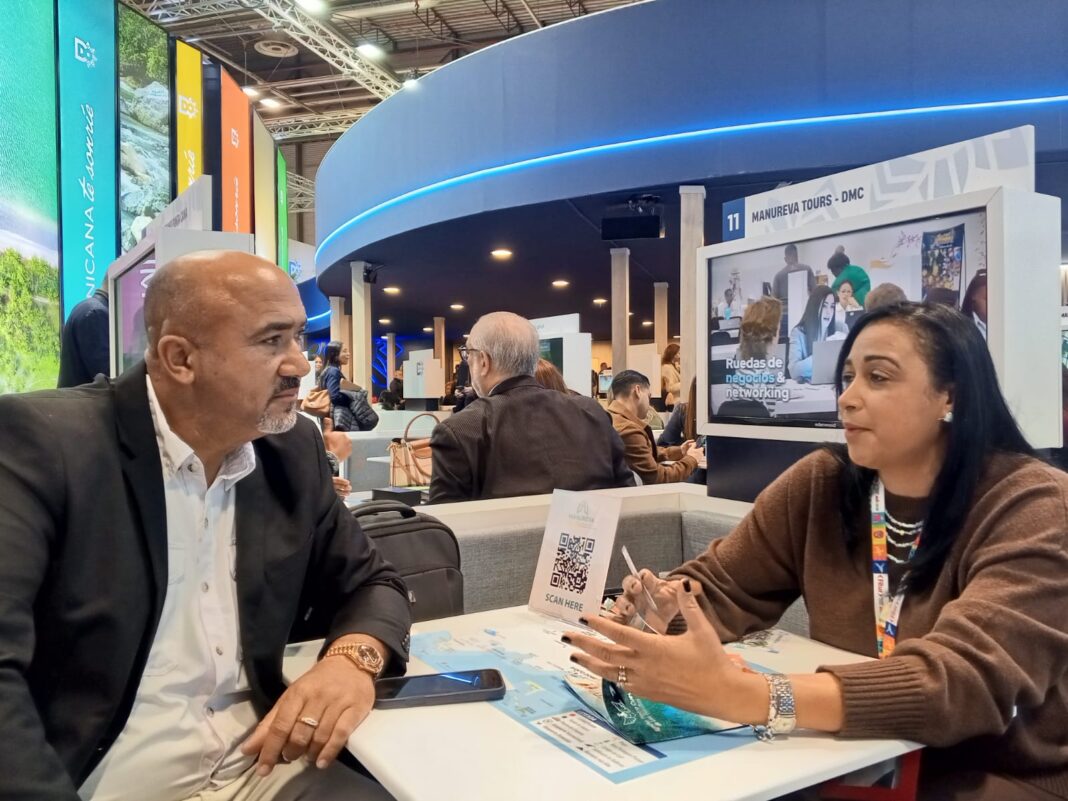 Santiago Rodríguez y Jakaira Cid del tour operador Manureva, conversan en un aparte en Fitur 2026.