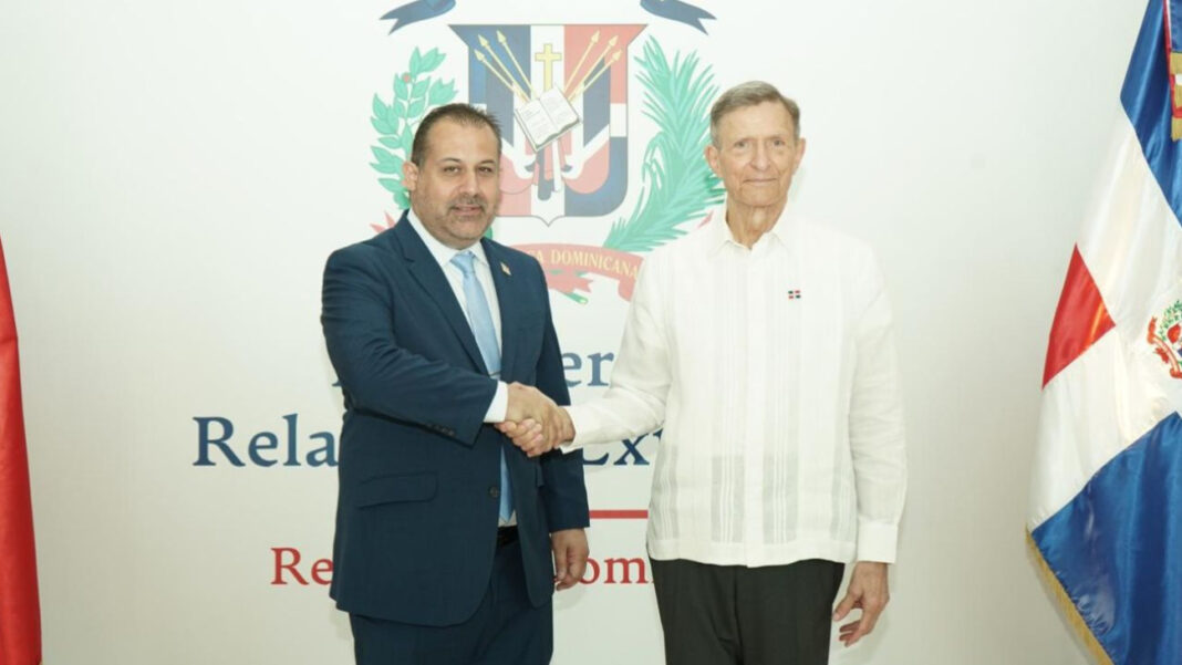 El canciller dominicano Roberto Álvarez (derecha) y el ministro de Transporte y Aviación Civil de la República de Trinidad y Tobago, Eli Zakour, se saludan tras la firma del acuerdo que procura fortalecer la conectividad aérea con nuevo acuerdo bilateral de cielos abiertos.