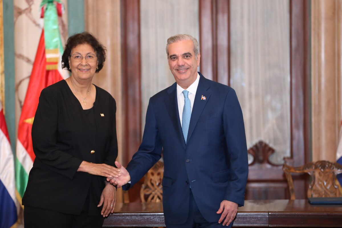 El presidente Luis Abinader y su homóloga de la República de Surinam, Jennifer Geerlings-Simons, se saludan tras la firma del acuerdo entre República Dominicana y Surinam.