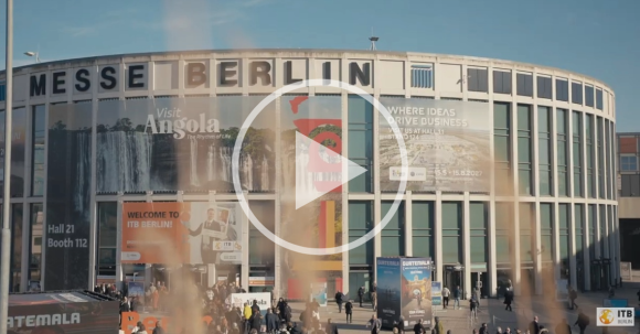Una foto de la entrada a la Messe Süd en Berlín con un botón de reproducción encima.