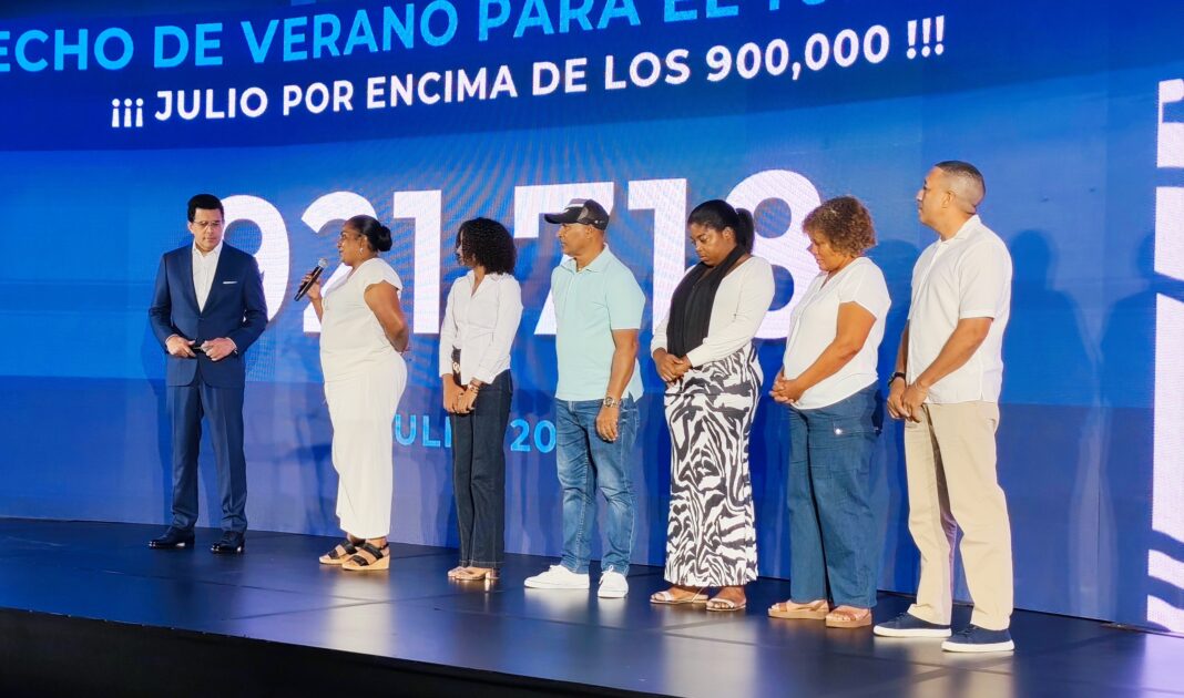 David Collado escucha el testimonio de Yanira Eusebio sobre cómo las inversiones del Mitur en las playas de Guayacanes y el turismo muestre el desarrollo que tiene en la zona.