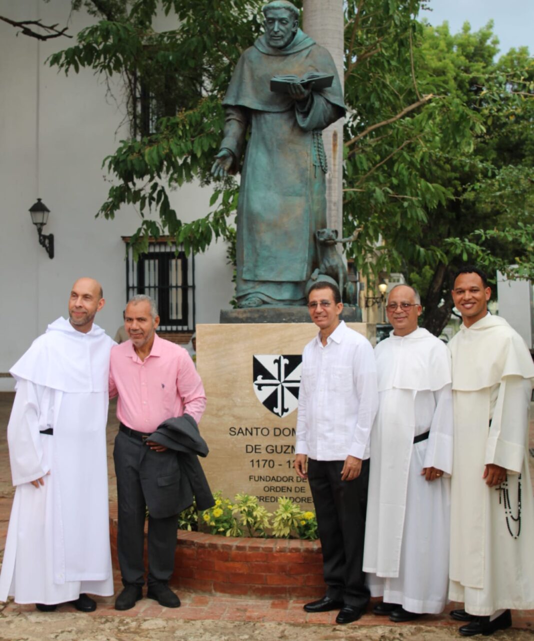 Los artistas Miguel Valenzuela y Dustin Muñoz junto a frailes dominicos frente a la escultura de santo Domingo de Guzmán