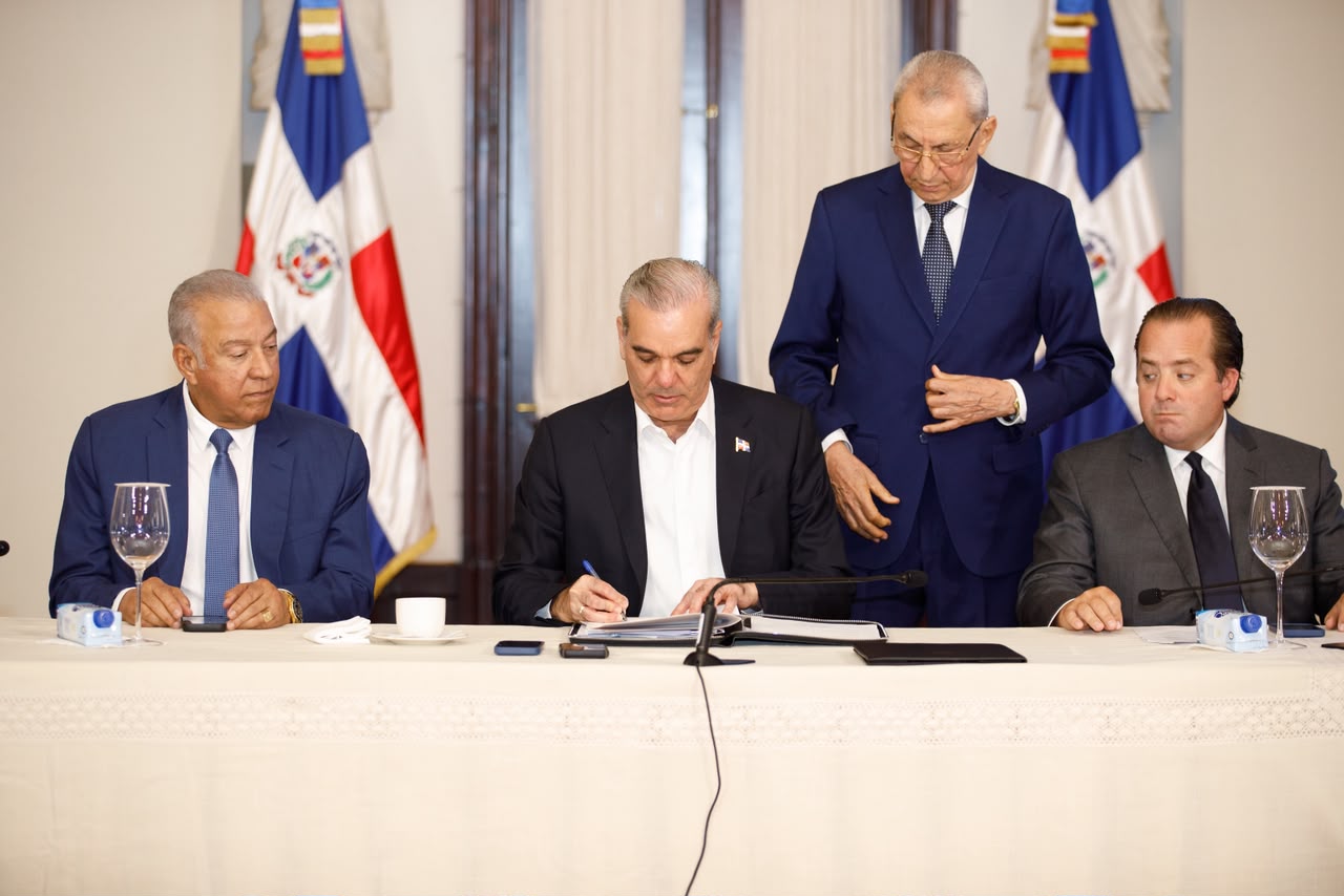 Momento en que el presidente Abinader firma el acuse de recibir los títulos de los dos parques nacionales titulados a nombre del Estado dominicano.