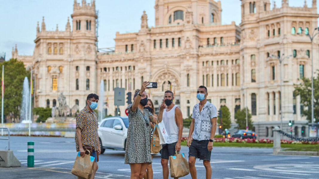 Turistas en la madrileña Plaza de Cibeles, en España, con el edificio del ayuntamiento a la espalda. La actividad turística en el mundo experimentó un muy leve repunte en 2021 y todavía está lejos de alcanzar los niveles existentes antes de la pandemia covid-19. Foto ONU Turismo.