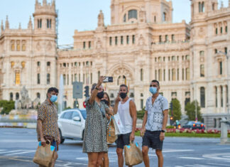 Ya no es si el turismo se recupera de una crisis, sino qué tan rápido: el hallazgo central de un nuevo estudio de TOURISE y Tourism Economics Turistas en la madrileña Plaza de Cibeles, en España, con el edificio del ayuntamiento a la espalda. La actividad turística en el mundo experimentó un muy leve repunte en 2021 y todavía está lejos de alcanzar los niveles existentes antes de la pandemia covid-19. Foto ONU Turismo.