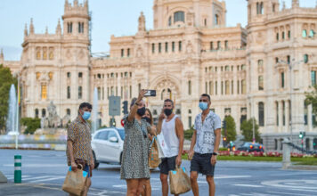 Ya no es si el turismo se recupera de una crisis, sino qué tan rápido: el hallazgo central de un nuevo estudio de TOURISE y Tourism Economics Turistas en la madrileña Plaza de Cibeles, en España, con el edificio del ayuntamiento a la espalda. La actividad turística en el mundo experimentó un muy leve repunte en 2021 y todavía está lejos de alcanzar los niveles existentes antes de la pandemia covid-19. Foto ONU Turismo.