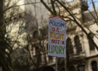 Bruselas abre la puerta a limitar el alquiler turístico en las zonas europeas bajo presión habitacional Un cartel de la protesta contra el costo de la vivienda en Lisboa en marzo de 2026. Foto tomada de Wikimedia commons compartida por Skift.